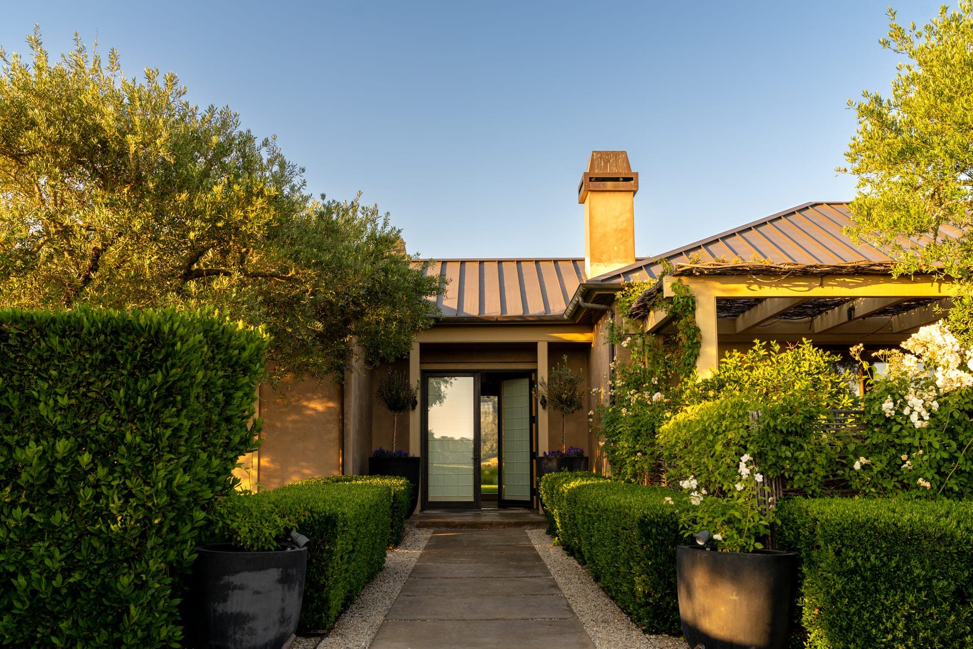 Landscape framing the entrance to the home