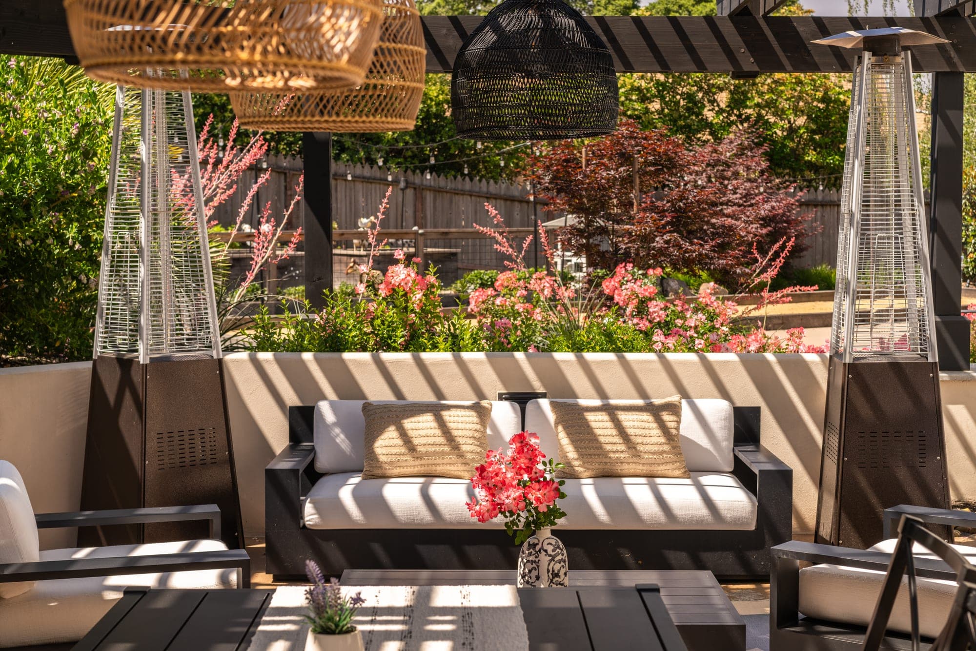 Covered outdoor lounge beside flowering plants