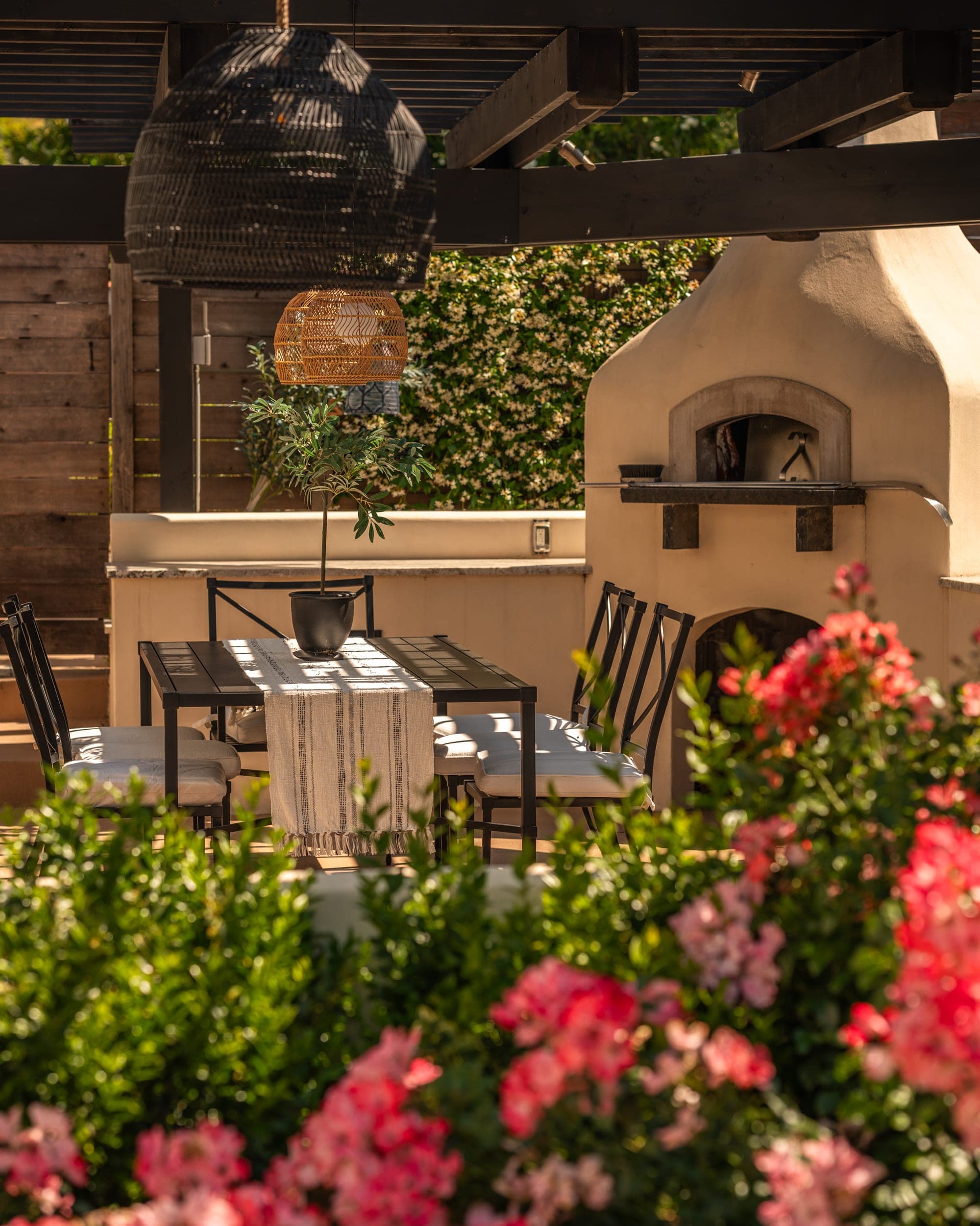 Outdoor kitchen and dining area framed by flowers